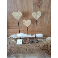 3 hartjes uit grenenhout behandeld met bijenwas op zwart metalen staafje op een basis van schors