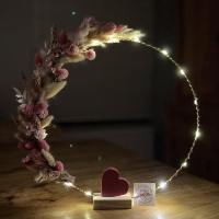 ronde decoratie met lichtjes, droogbloemen en een eenvoudig hartje centraal op de basis 