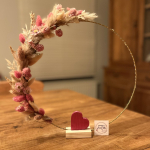 ronde decoratie met lichtjes, droogbloemen en een eenvoudig hartje centraal op de basis 