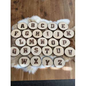 Letter in pyrografie op boomschijfje