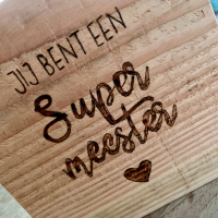 Tekst einde schooljaar in pyrografie op hout