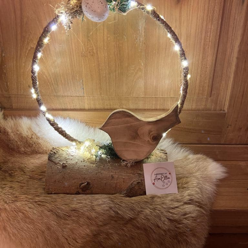 vogel uit gewaxt grenenhout tegen een met jutetouw omwonden ring gedecoreerd op een stronk van natuurhout